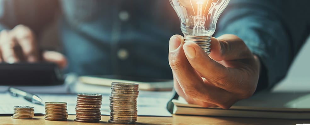 Light Bulb Stack Of Coins | Orange Energizing Solutions
